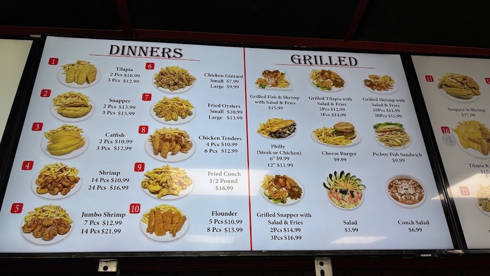 Menu board listing wings, catfish, and dinners.